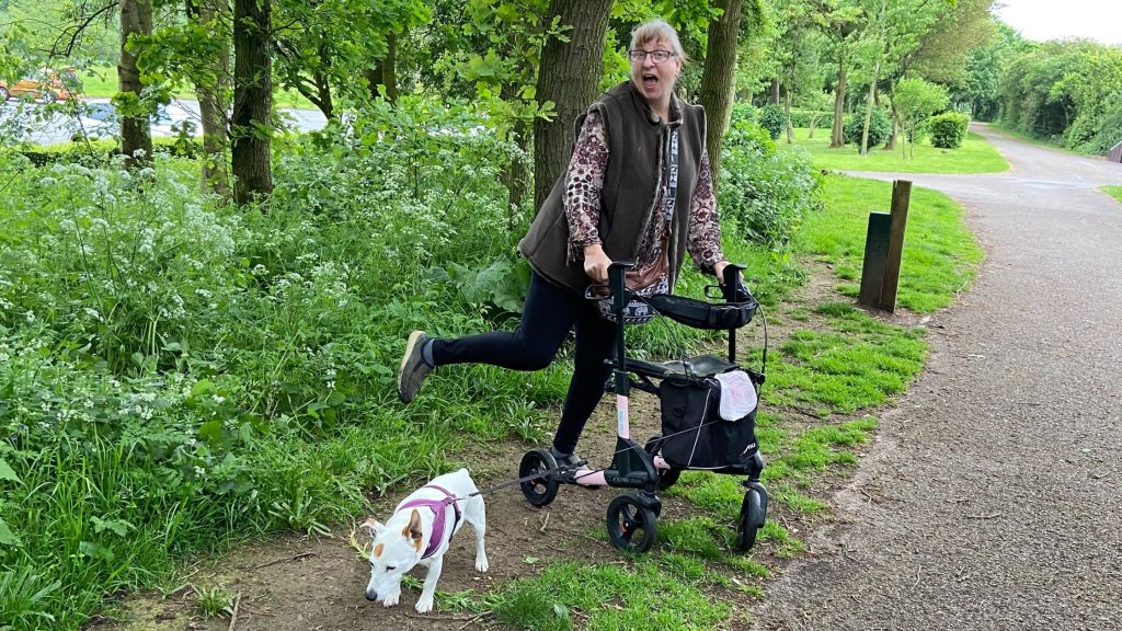 Lyndsay and Burt posing with the new walker on a woodland path
